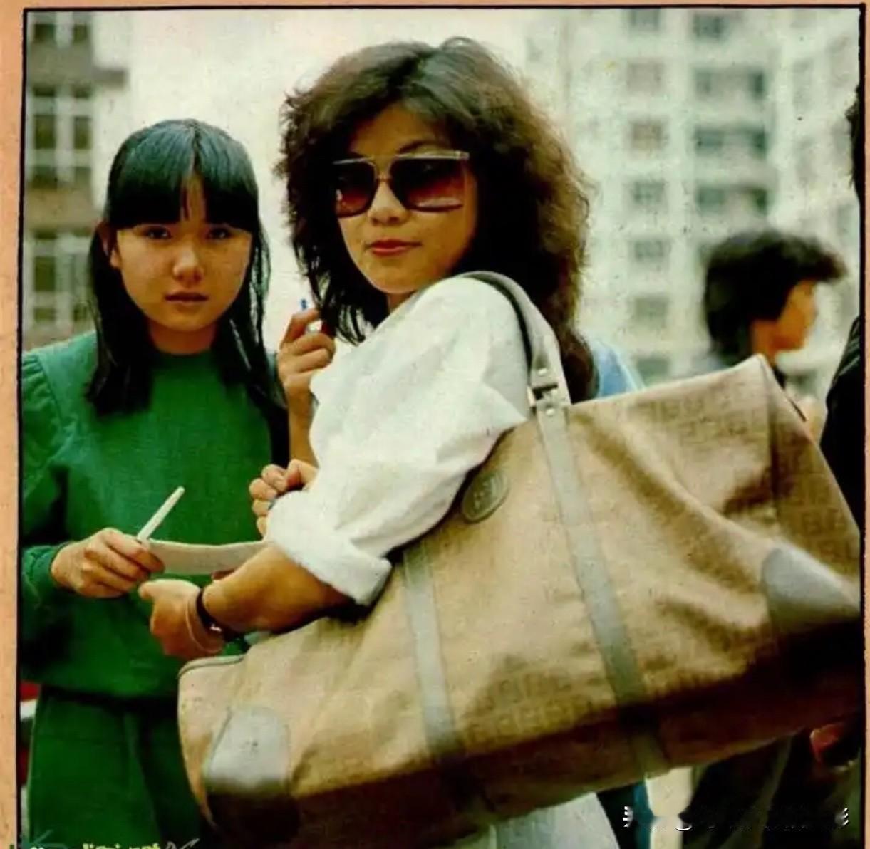 翁美玲背这个大包，往那儿一站，就像把80年代港圈的时髦气全背身上了。简单穿件白上