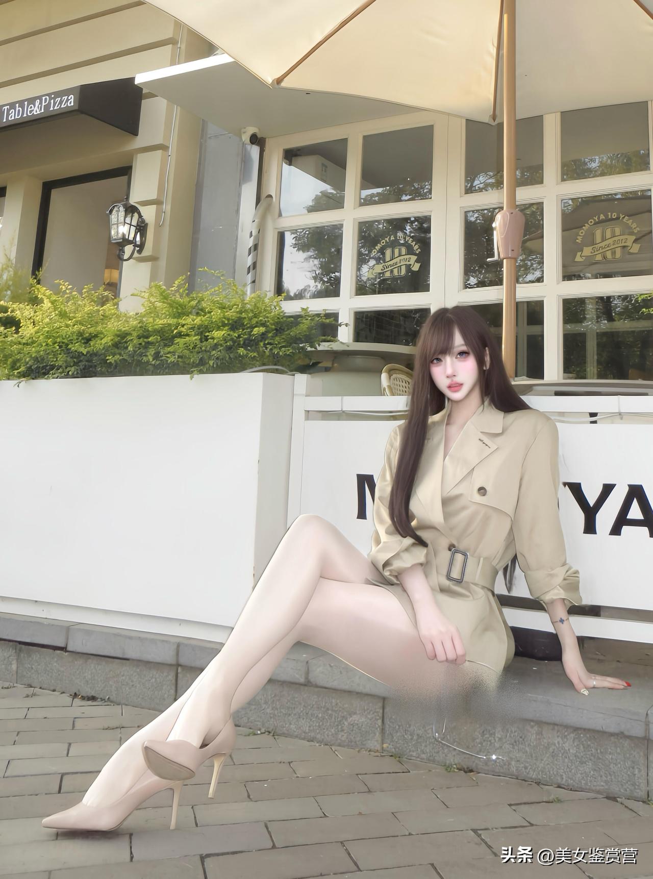 暖调的午后，米色系的短款风衣在光影里晕开一层柔和的光泽。
收腰设计与双排扣的细节