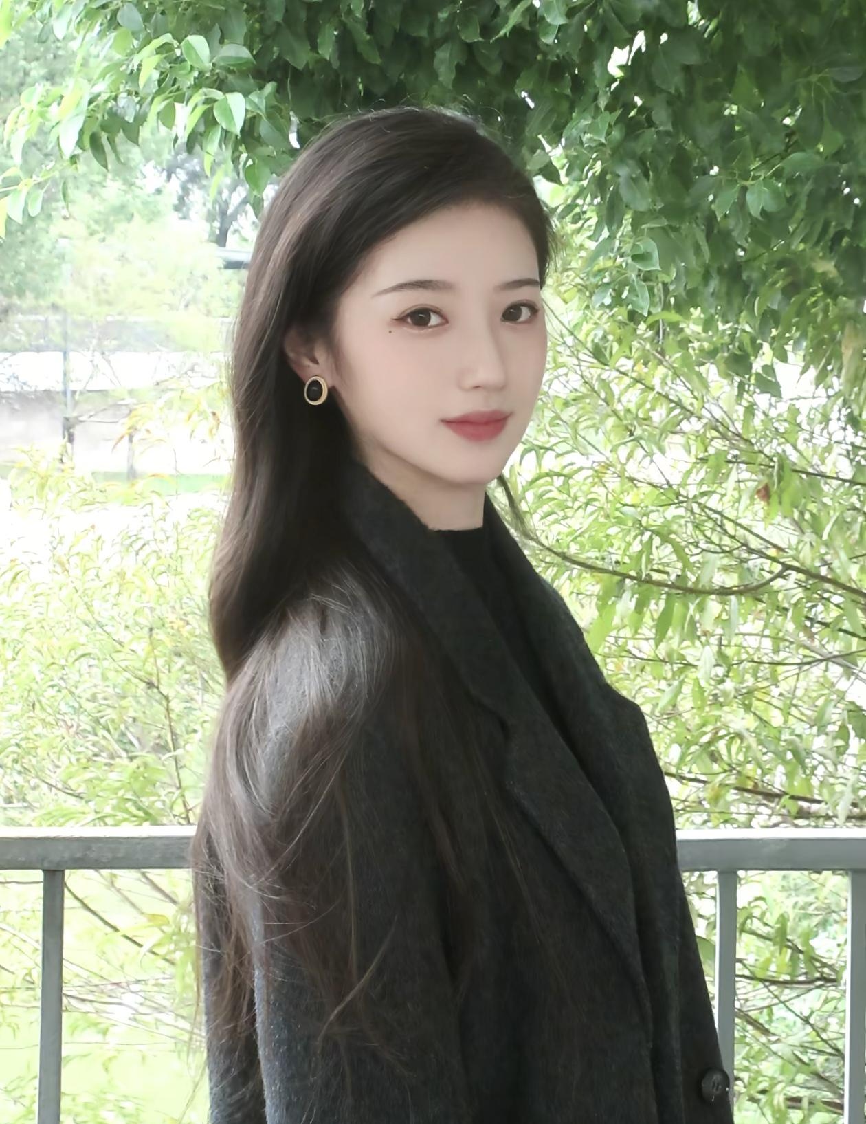 优雅黑衣少女，静谧绿意中，温柔微笑