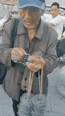 第一次见到这种小玩具，几根铁丝在老人的手上真是变幻无穷。            