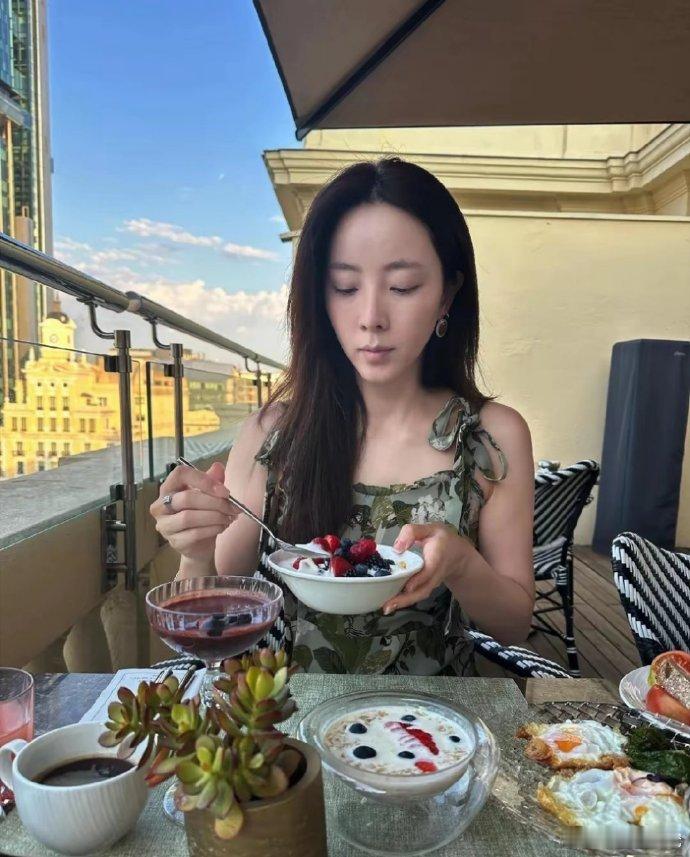 李思思于西班牙，悠然分享今日碎片。身着吊带连衣裙，墨镜一戴，惬意尝美食，尽享异国