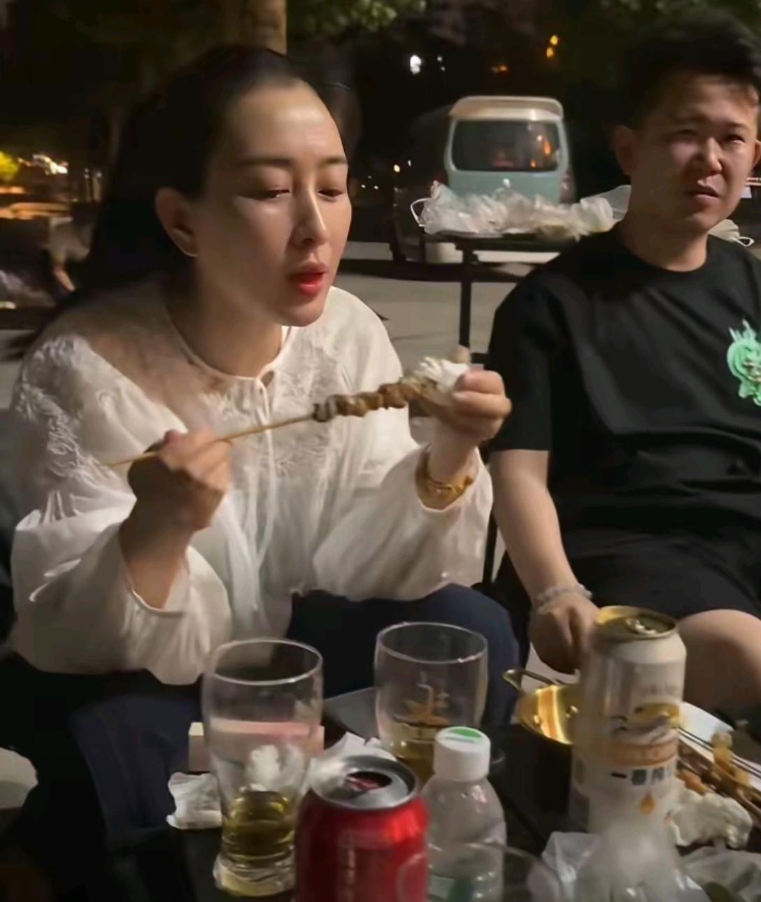 美女在大马路的地摊上吃烧烤，接地气