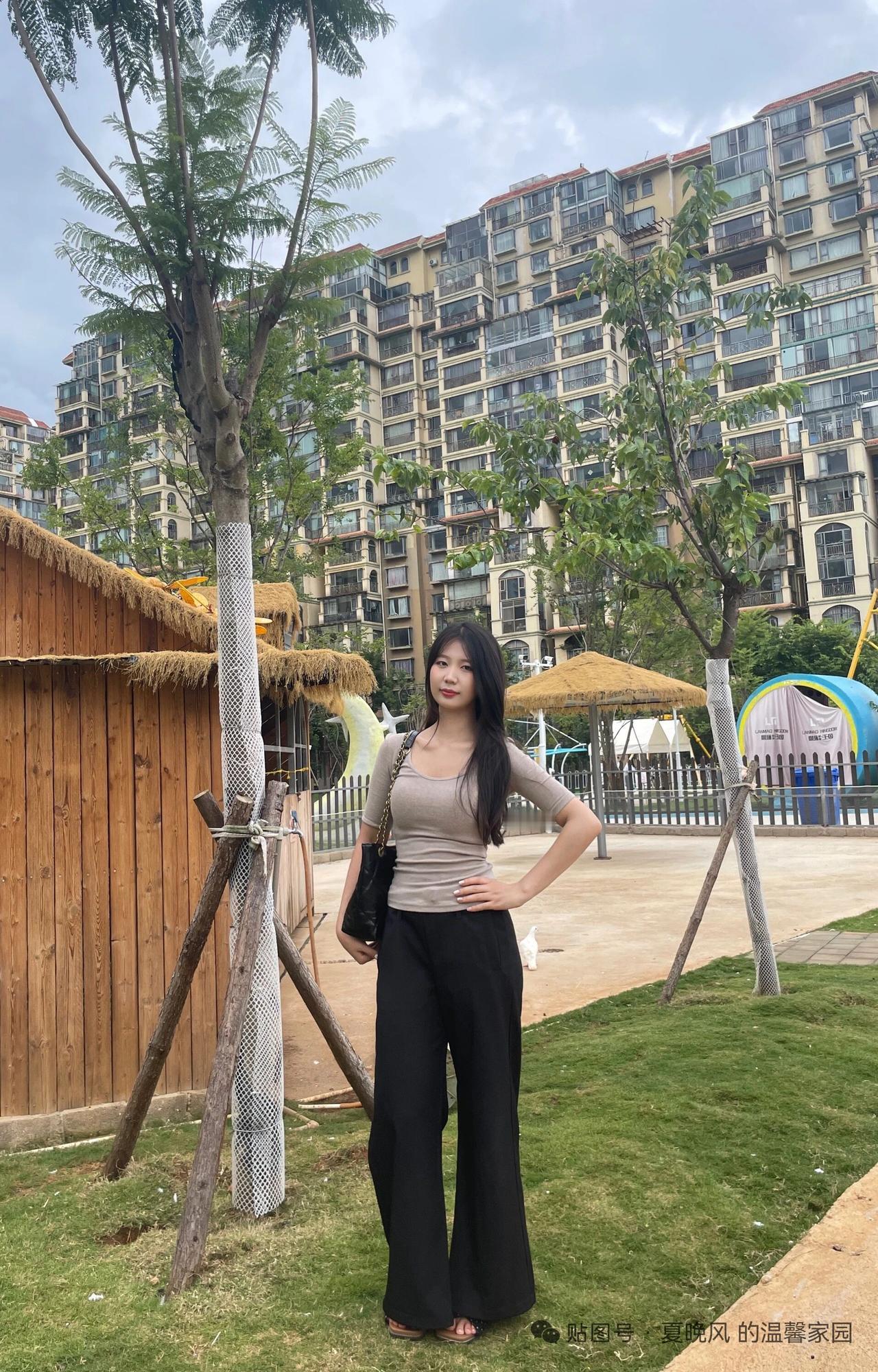 在公园里拍照，背景是高楼。