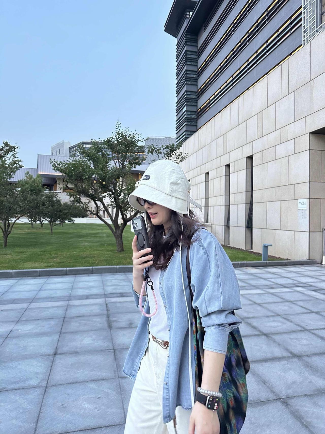 路人偶遇梅婷，气质太好了。浅蓝牛仔衬衫叠穿白内搭，宽松版型随性慵懒，搭配米白色阔