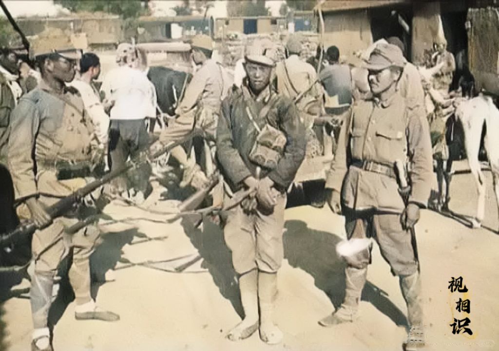 1941年，一名年轻的八路军战士被日军俘虏后的照片，他的双手被绑，两名日本兵一左...