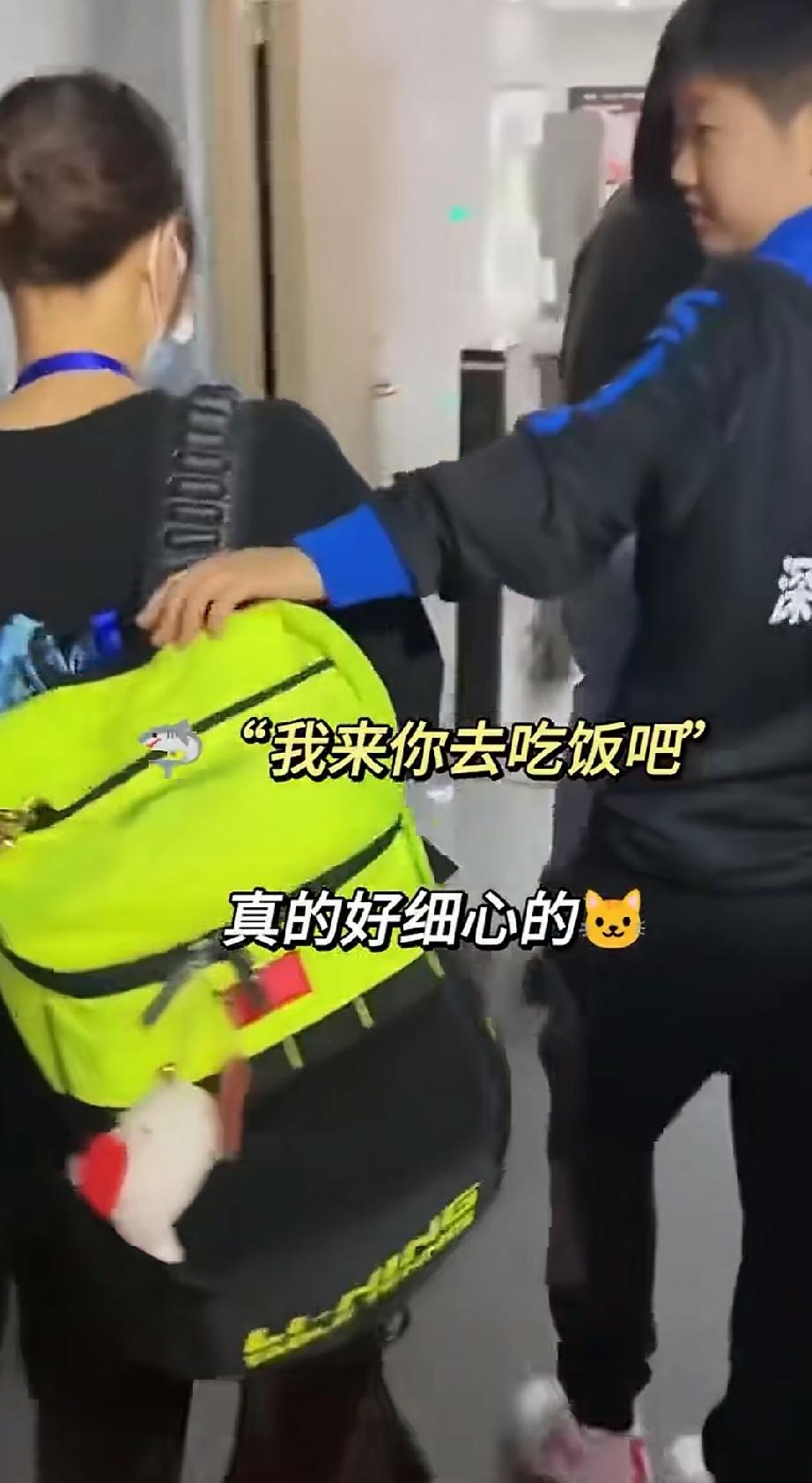 伸手结接住小队员身上的背包的莎莎好实在。
穿着深大俱乐部的衣服，训练回来，莎莎作