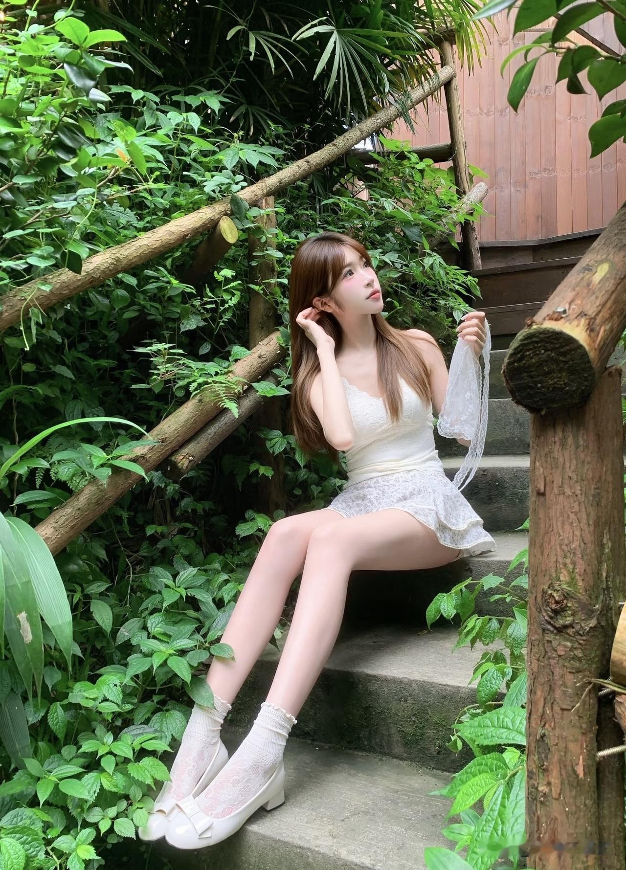 夏日清新穿搭，白色蕾丝裙搭配高跟凉鞋，置身绿意盎然的花园中，尽显优雅与自然。