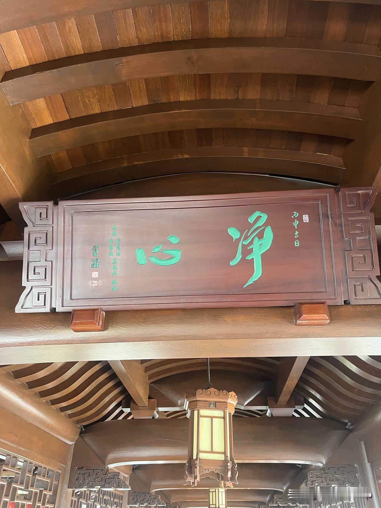 今天在玉佛禅寺拍到这块“净心”牌匾的时候，风刚好吹过殿侧的罗汉松，落了半片松针在