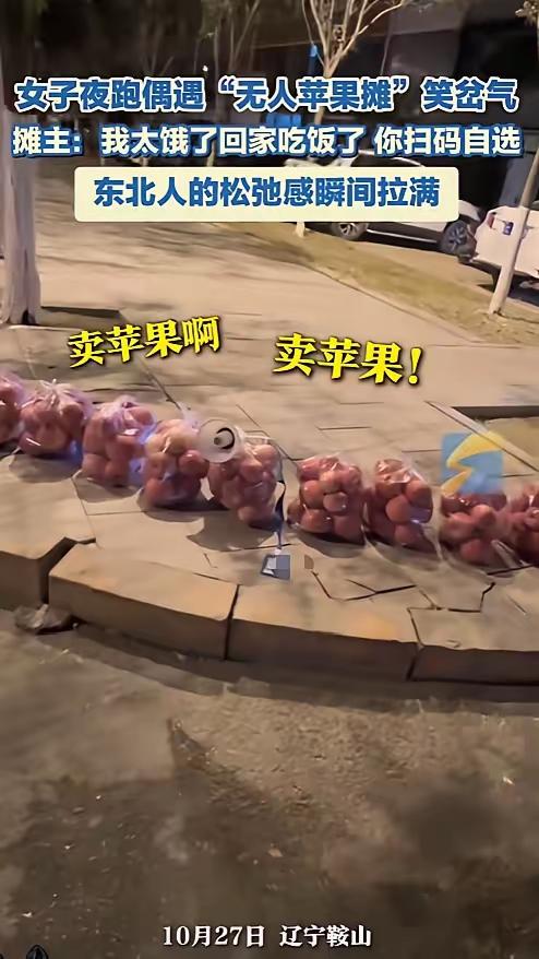 “笑不活了！”10月27日，在辽宁鞍山，一名女子夜跑时邂逅了一个无人苹果摊。几袋