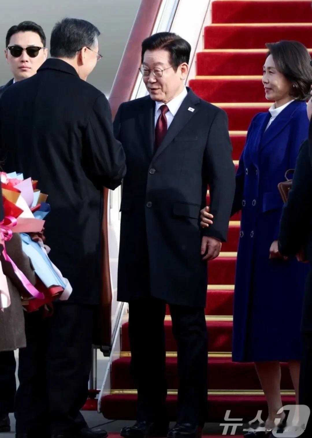 韩国总统李在明带着老婆和团队，现身机场。
61的李在明戴着黑框眼镜，扎着红领带，