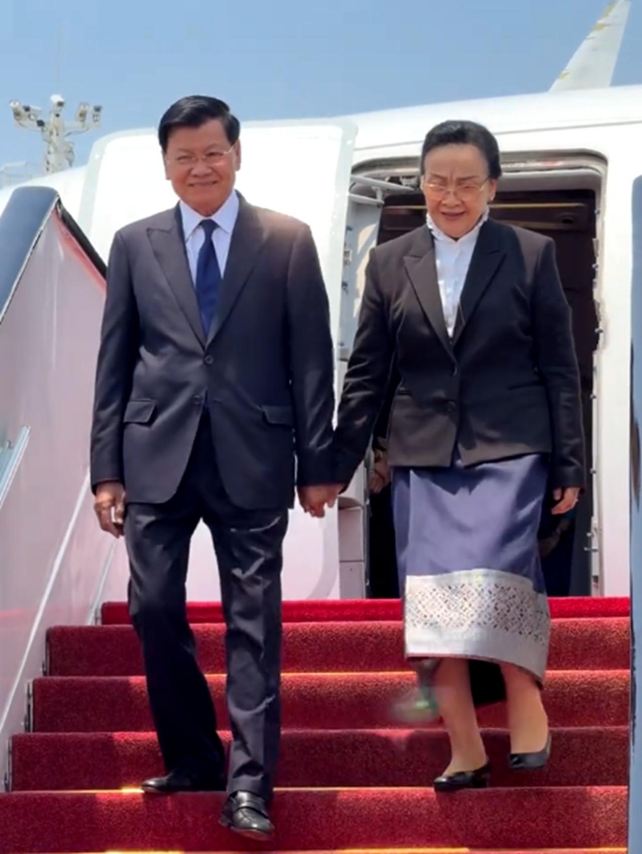 6月2日通伦携手夫人娜丽抵达杭州机场；老挝主席走出机舱，然后牵手娜丽，夫妻俩一起