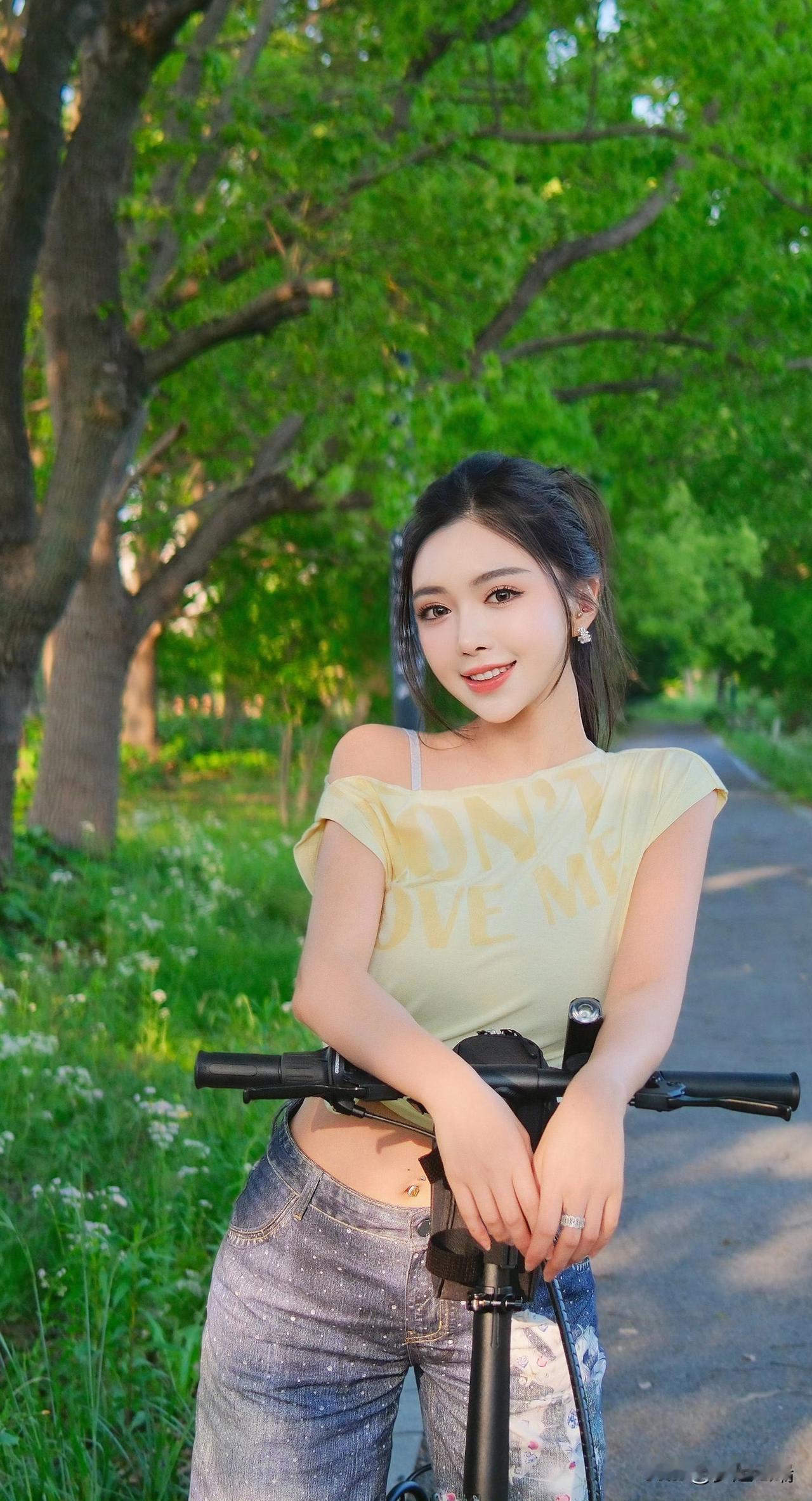 阳光明媚的午后，少女与自行车在绿意盎然的公园中，笑靥如花。