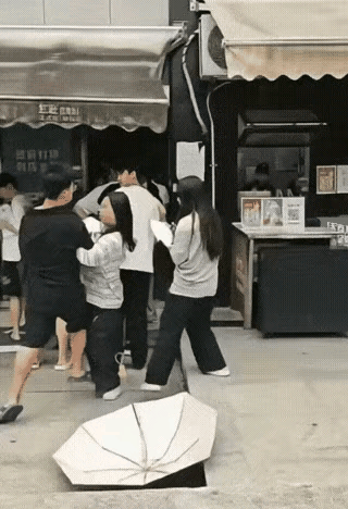 女生排队打伞☔碰到了男子的头。双方发生争执后，女生先用伞然后用手打男生的脸。然后
