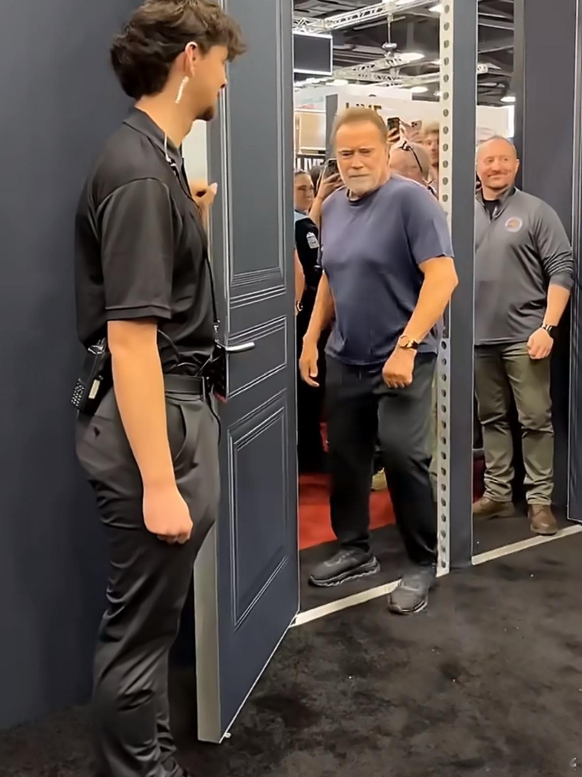 施瓦辛格假装被自己的大肌肉卡住 刷到施瓦辛格最新搞笑一幕：侧身卡窄门，表情极其痛