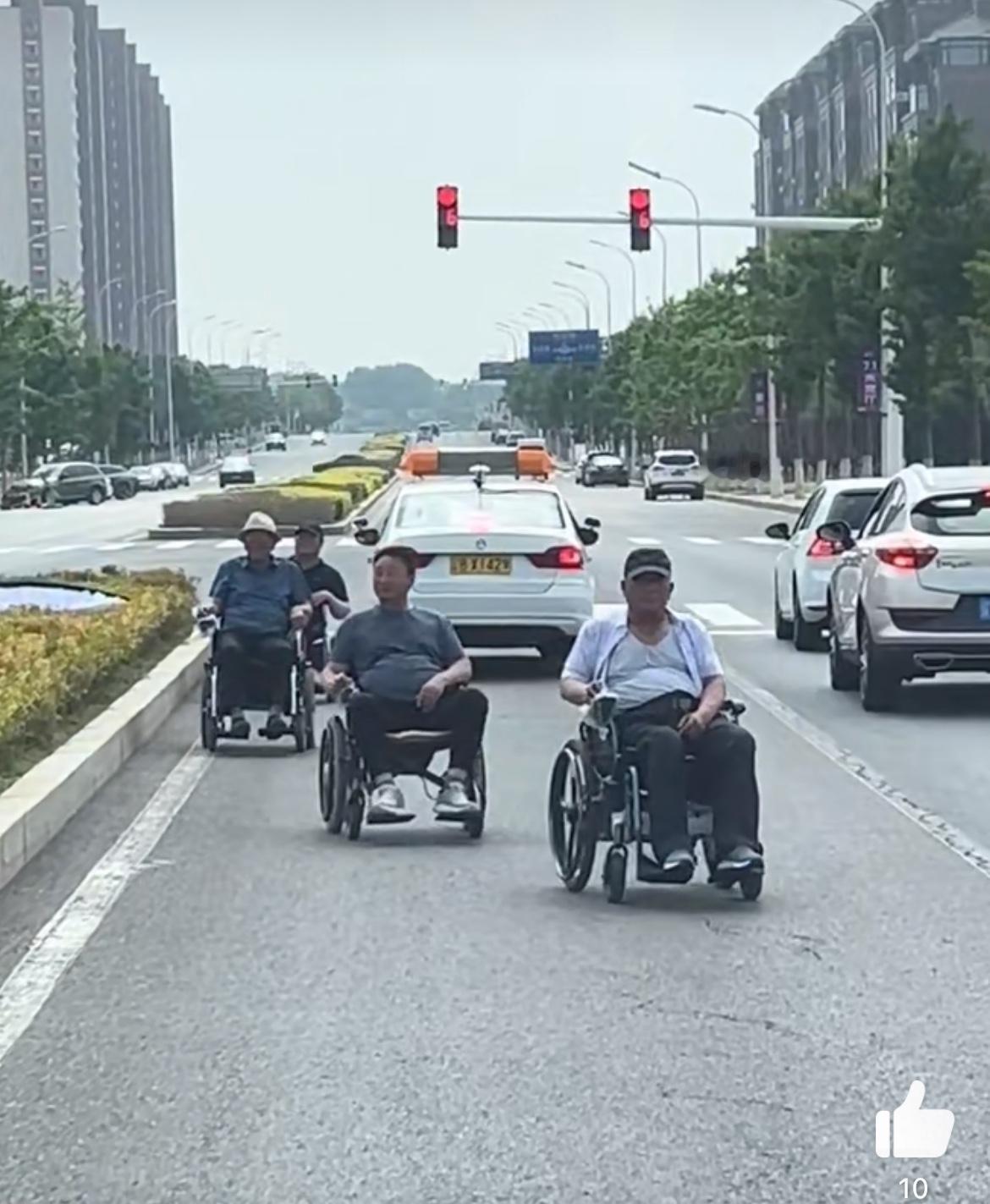 一群坐着轮椅的假残疾人，逆行横穿马路，就当自家小区一样悠哉悠哉。这是大爷们组团出
