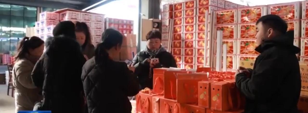 第一张图里，年货市场中堆叠着红彤彤的礼盒，顾客们围在摊位前挑选、交流，红色的包装