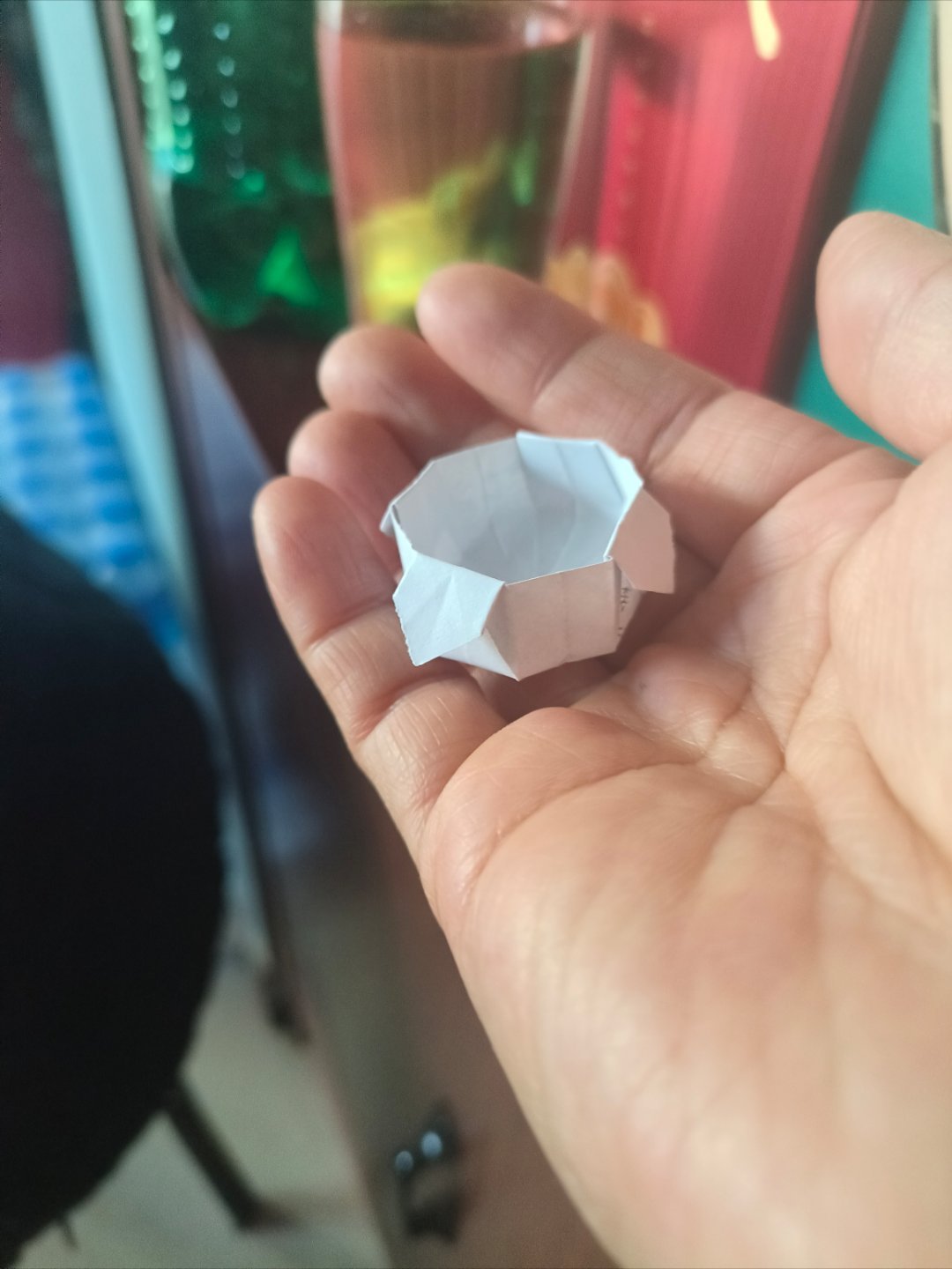 来，看看老板娘的手巧不巧，这么小的纸也能给折出花来，像小篮子，就是没提手的小篮子