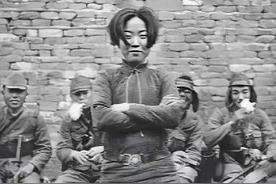 1938年，四名侵华日军坐在板凳上，看着一个女子，该女子双手交叉环抱，面露笑容，