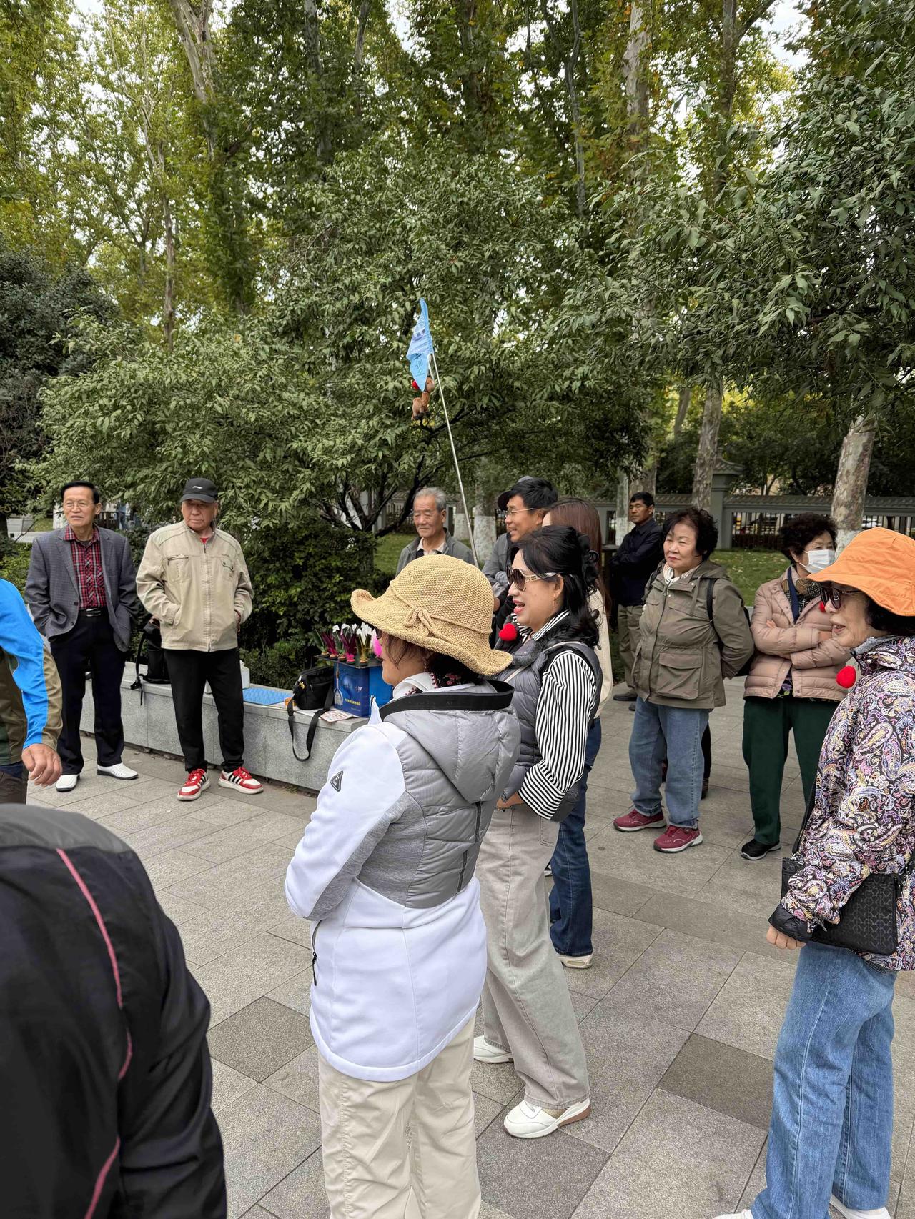 昨天上午，我逛西安兴庆宫公园，走到东门北边的踢毽子广场时，看到一个打旗的，像是导