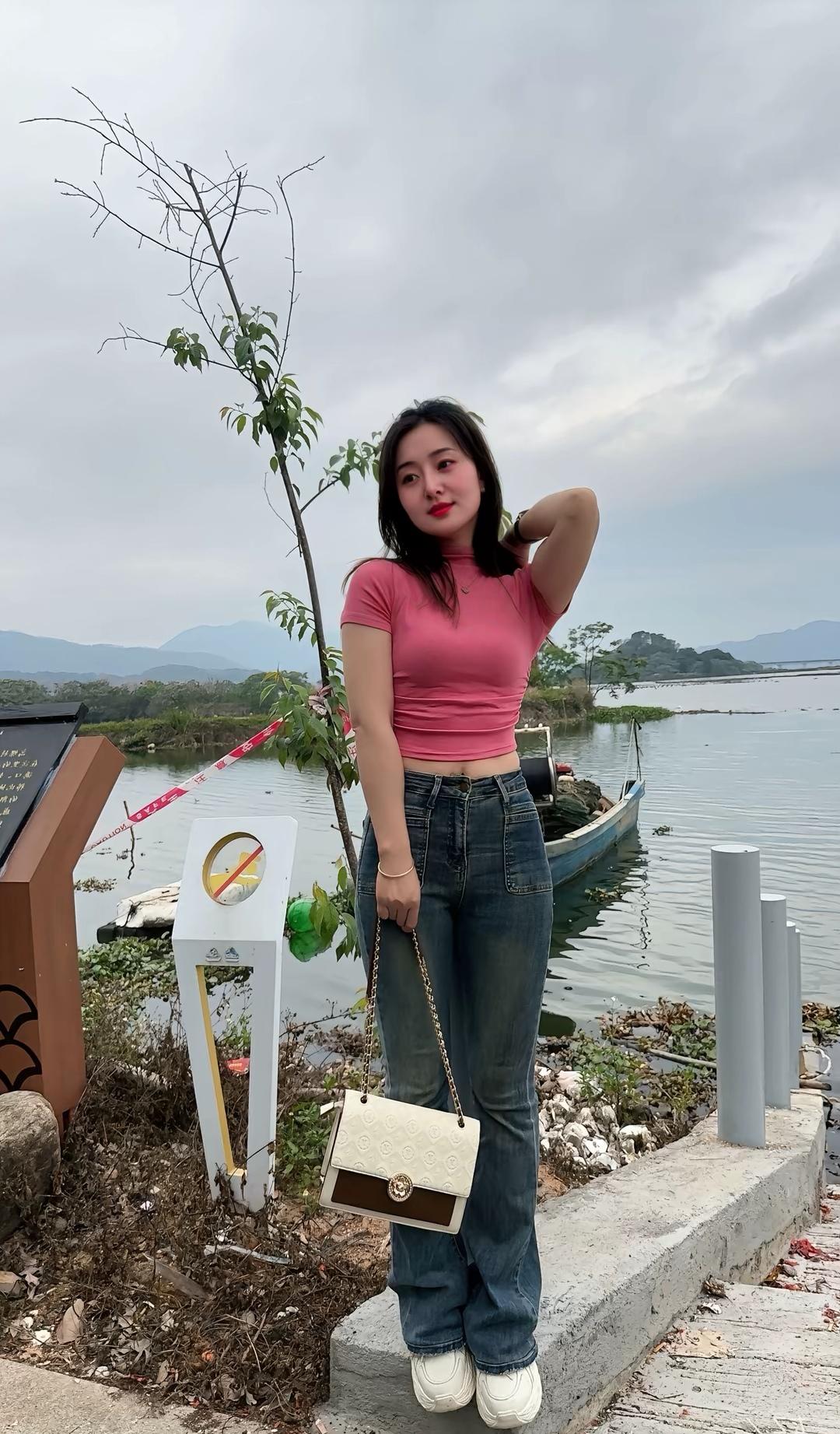 湖畔漫步，粉色上衣与牛仔裤的清新搭配，尽显自然之美。