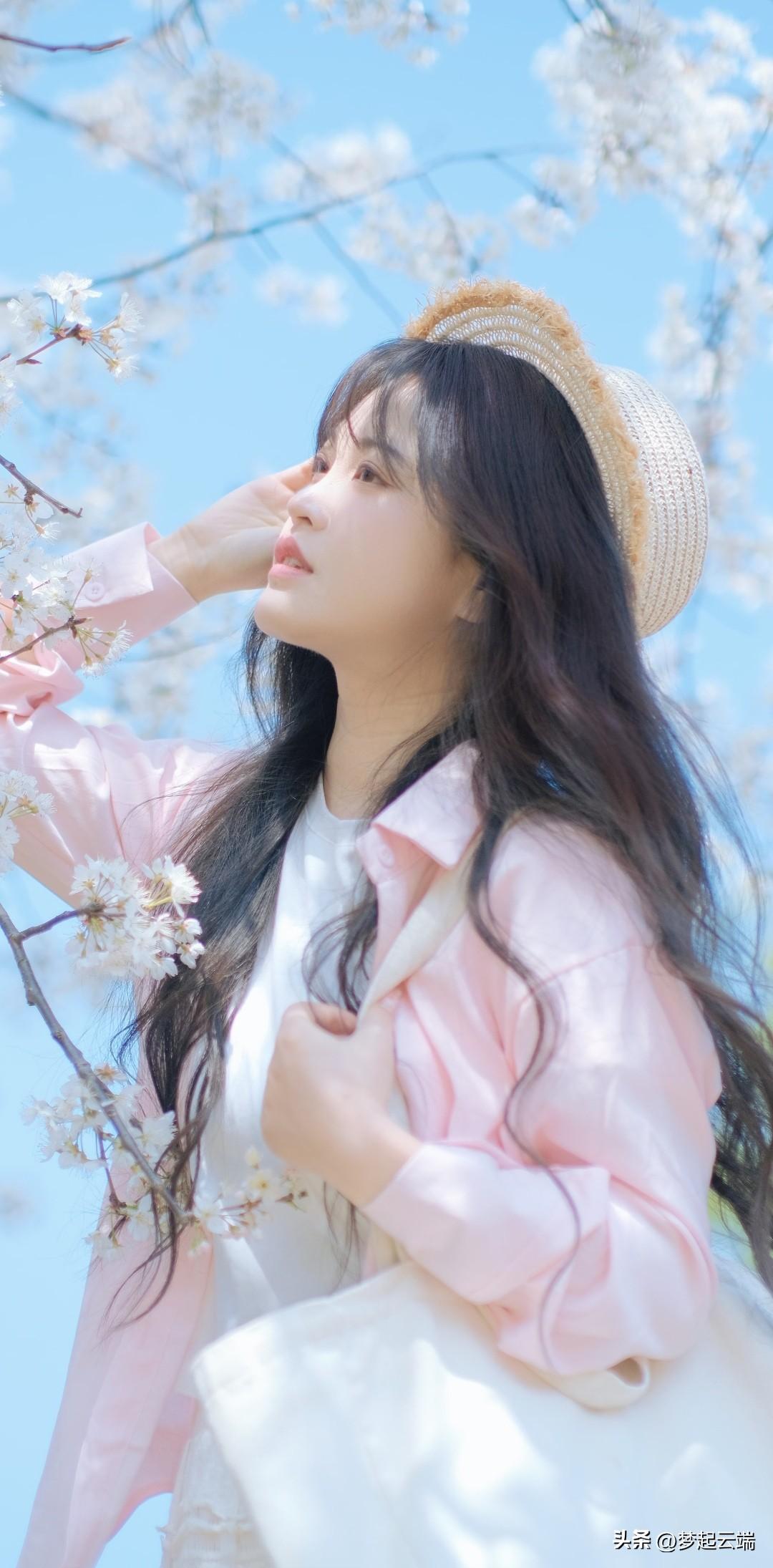 春日花海中的少女，浅粉外套与草帽相得益彰，温柔动人。