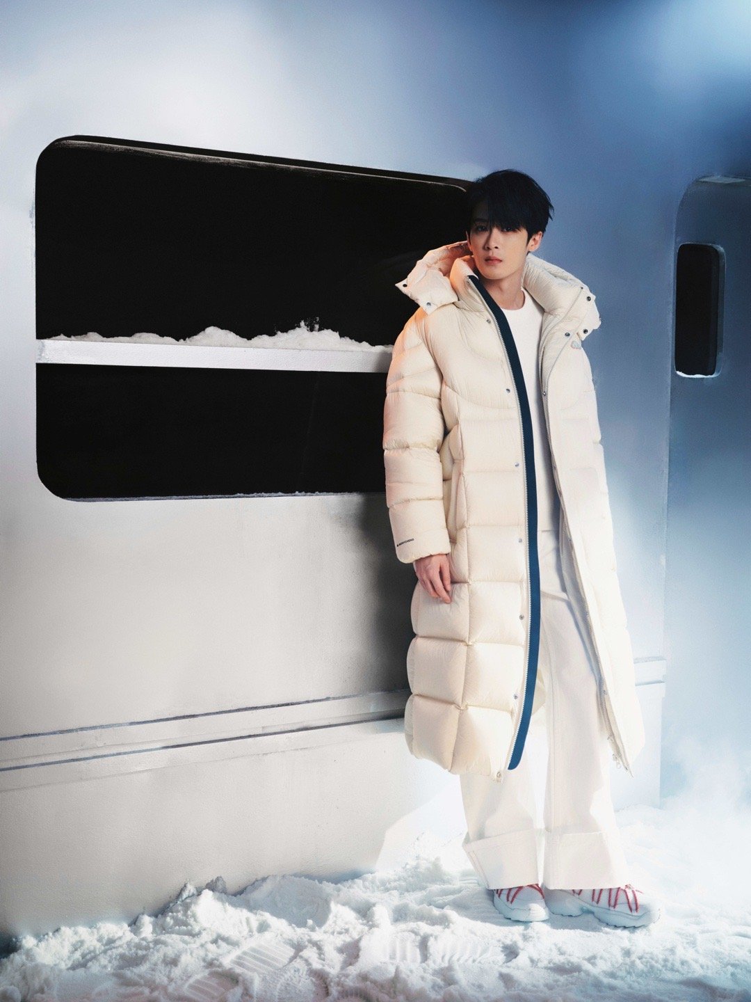 檀健次 × 品牌直播造型 Look，身穿长款羽绒服搭配白色阔腿裤，于冷暖光影之间