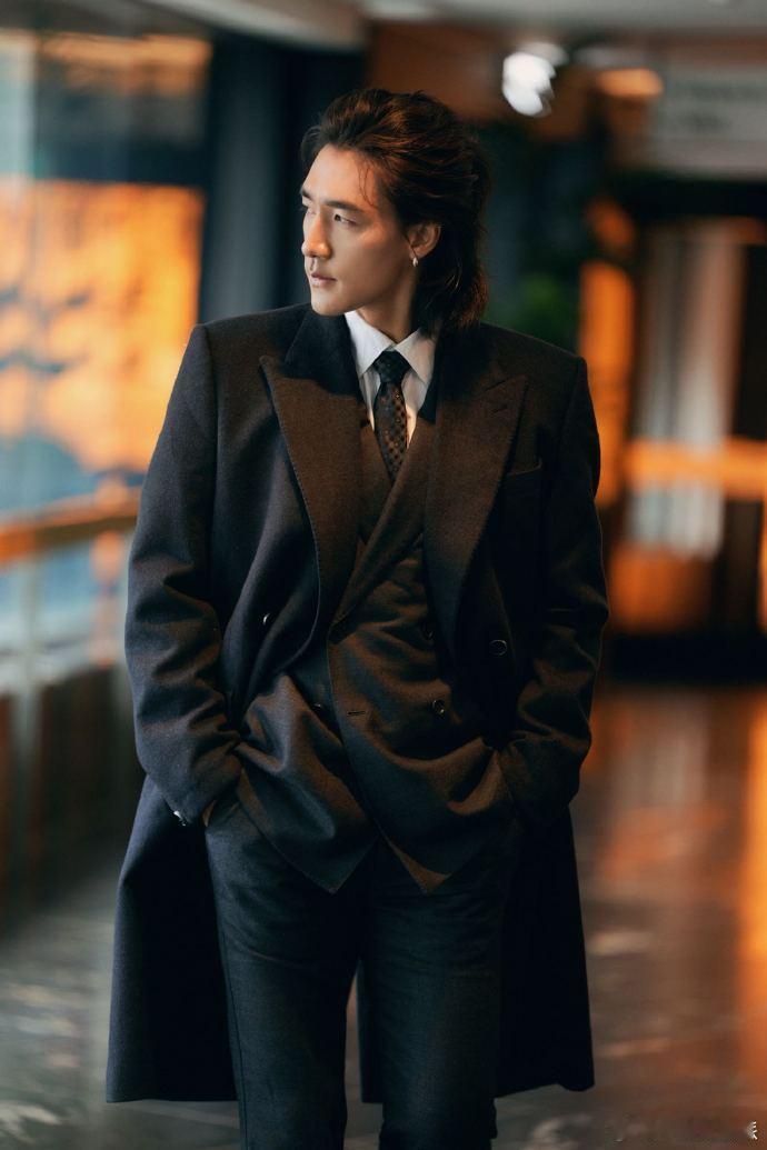 此沙穿黑风衣气场全开，宽肩廓形撑出气场，西装领正经混松弛感，风一吹衣角乱飞，远冷