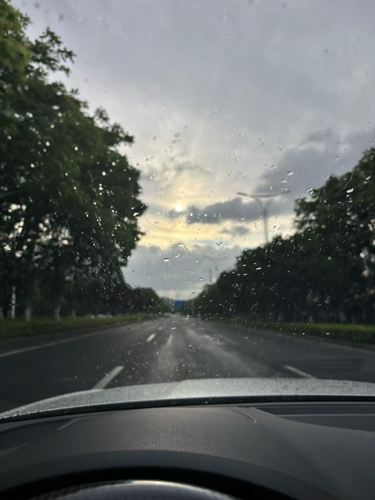 记录我的2026雨丝敲打着车窗，前路被晕染成温柔的雾色。夕阳从云层里漏出一点微光