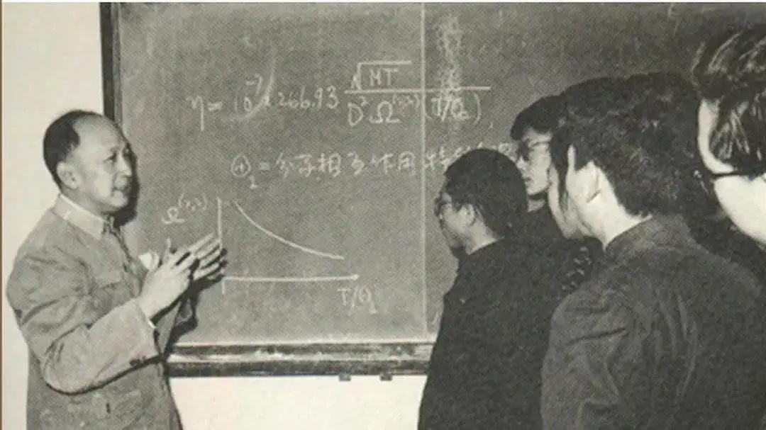 60年代，钱学森正在黑板前为学生授课时的一幕，镜头中他在黑板上写好了公示，讲述反