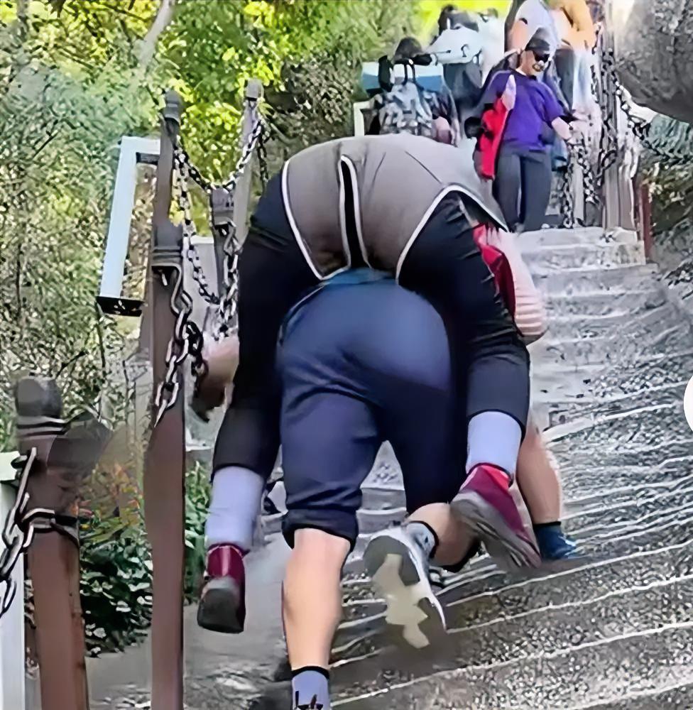 华山山势陡峭险峻，年轻人攀爬本都耗费体力。背着老太太手脚并用登山风险极高，山路狭