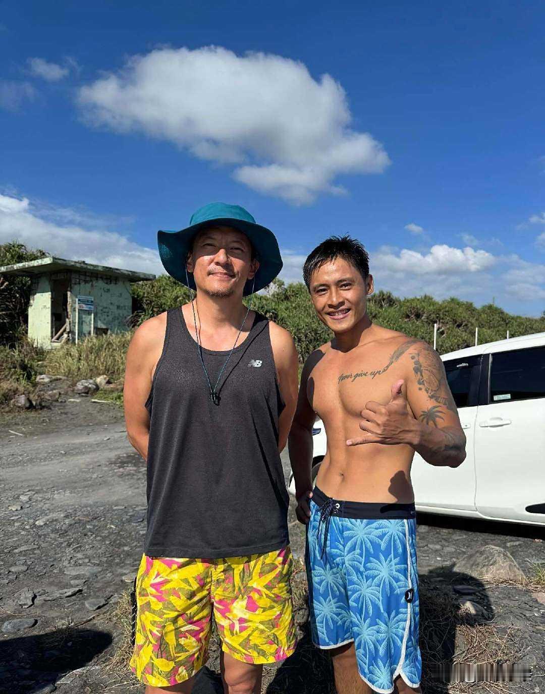 49岁张震到海边冲浪被偶遇，他穿着黑色背心，戴着遮阳帽，身材好壮硕，胸肌饱满，皮