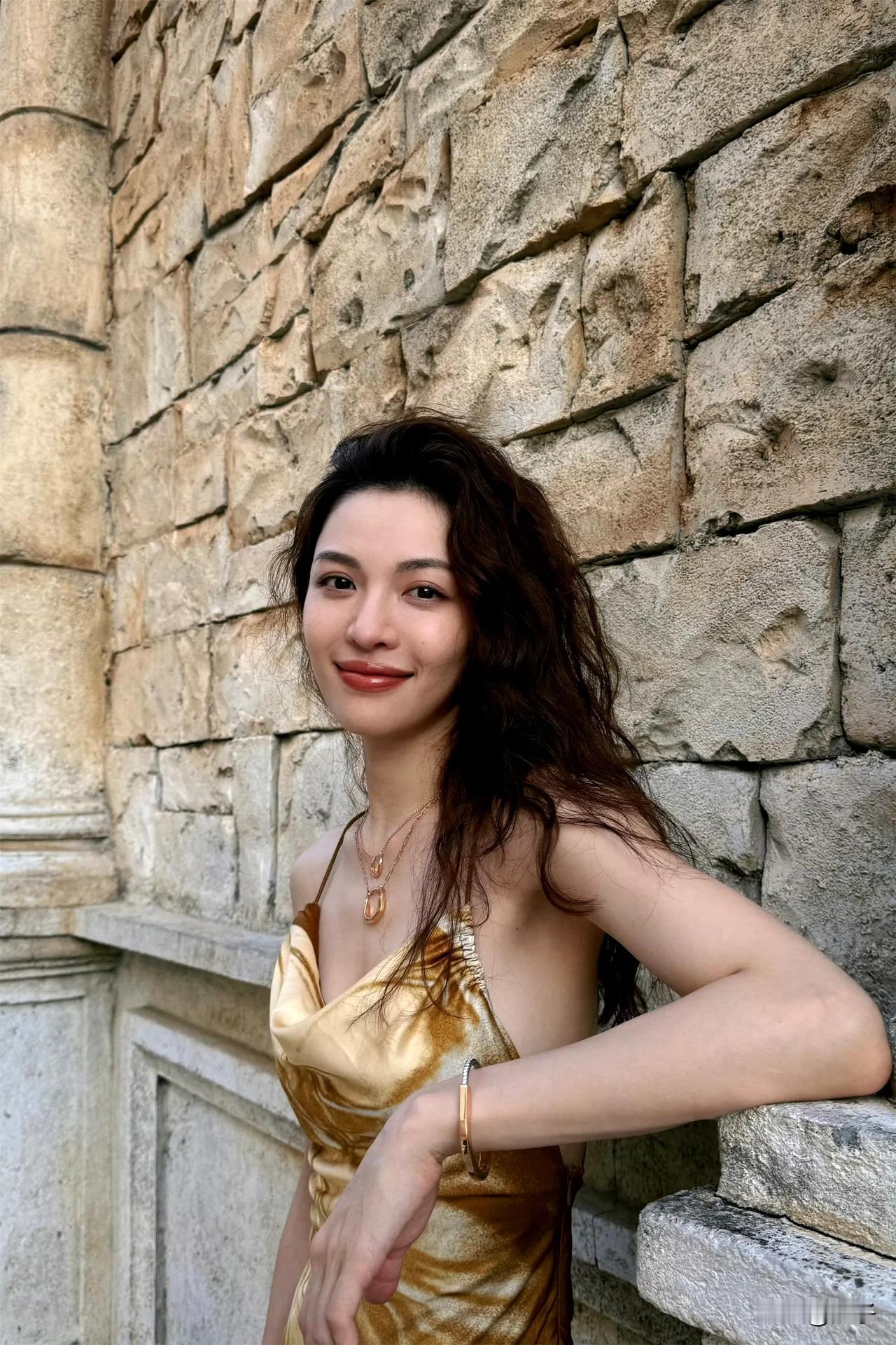 钟楚曦夏日金色吊带连衣裙浪漫，搭配一头微卷飘逸的长发散发着无限的魅力 ​​​。这