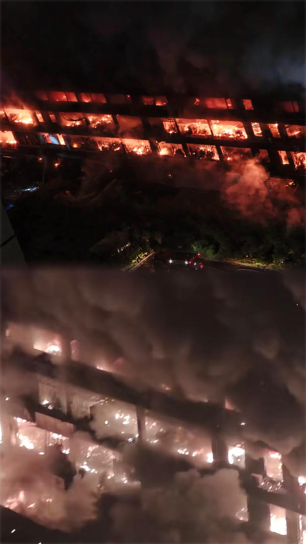 夜幕下的火灾现场，浓烟滚滚，火光冲天，紧急救援正在进行中。
