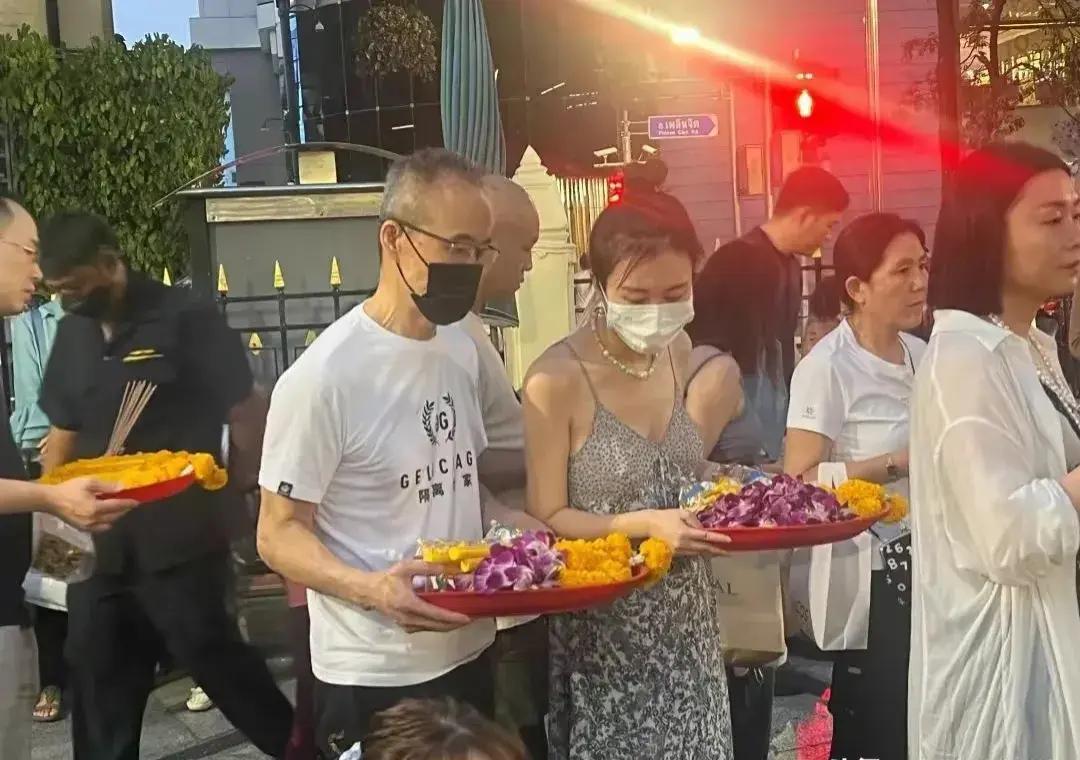 73岁王石携3岁女儿和42岁娇妻去泰国拜佛！田朴珺穿深V吊带裙光脚跪拜，比老公还