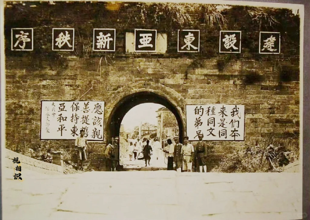 1938年，日本攻占吉林梨树县后，为了抵消军民的抗日意志，在城墙上打出...