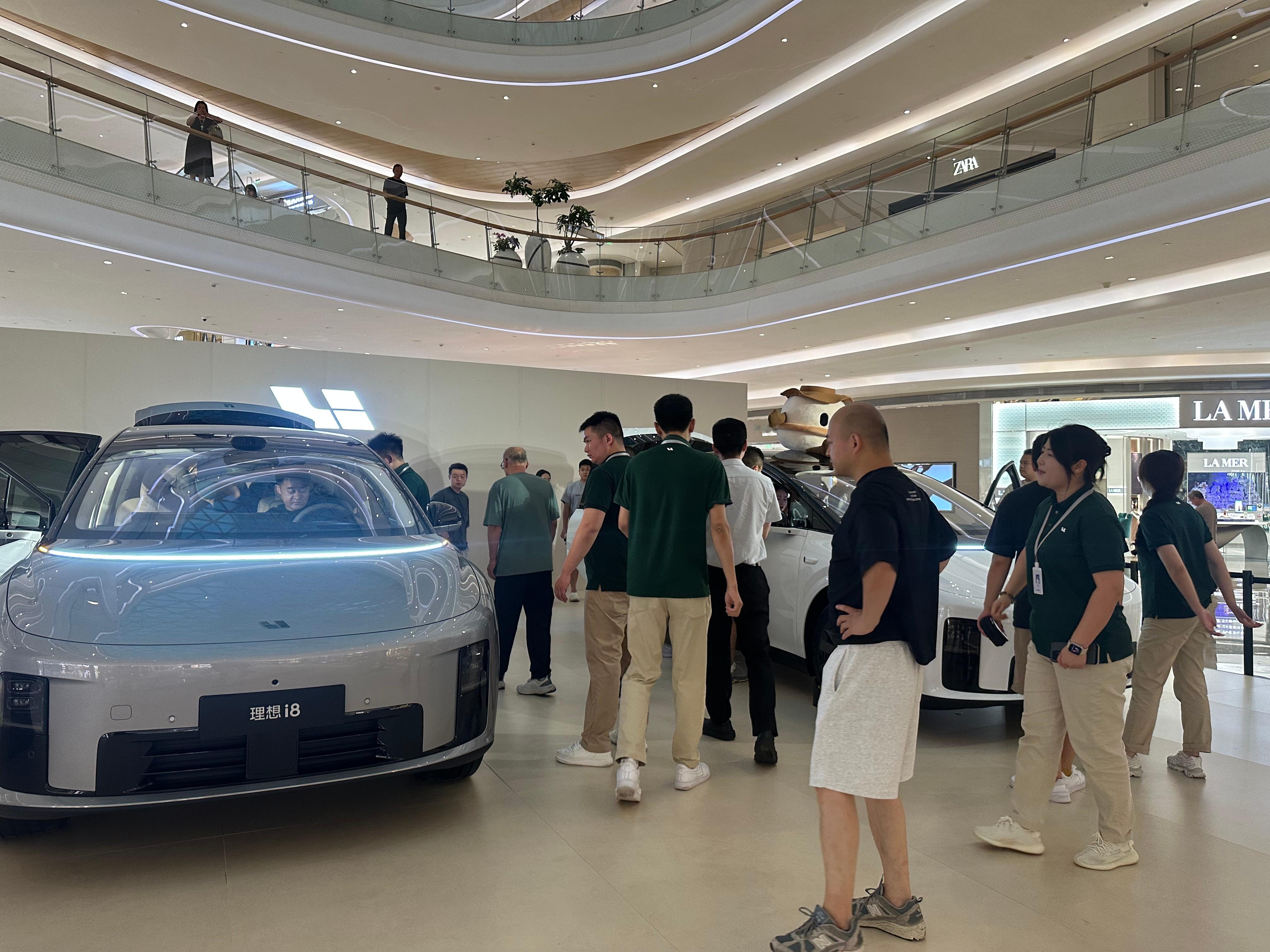 理想i8巡展在商场里，看车的人真多，很多都是一家几口来的，各自都在车上找属于自己