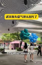武汉街头蓝气球太出片了 蓝气球在武汉的街头轻盈飘动，与古老的建筑和繁忙的街景交相