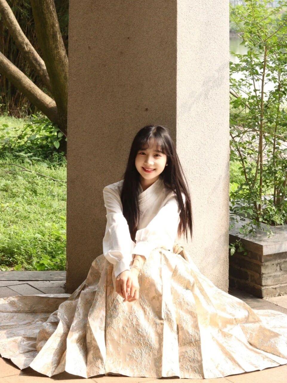 在绿意盎然的庭院中，她身着一袭优雅的汉服，宛如画中仙子。发一张你相册里最美的照片