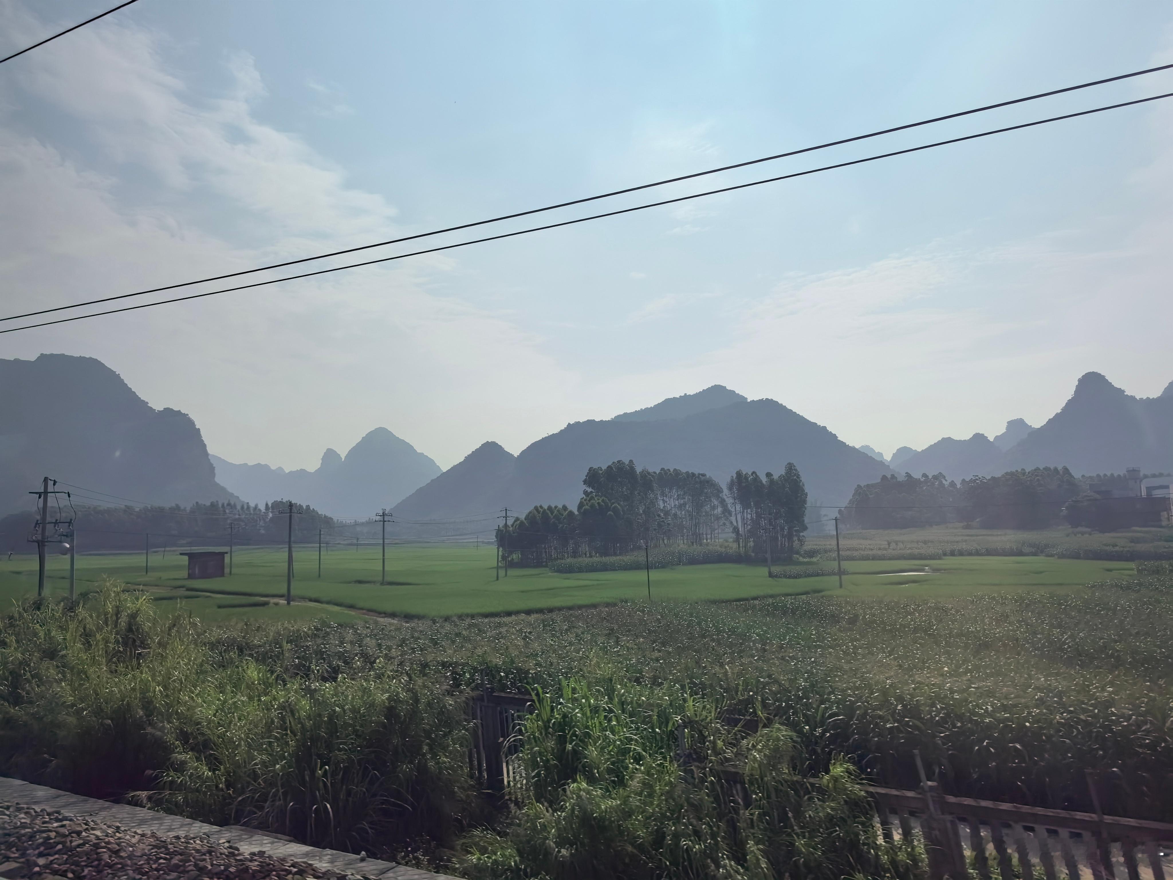 在从#南宁# 去往桂林的高铁上，路两旁是飞逝而过的美景，那连绵的群山，成片的稻田