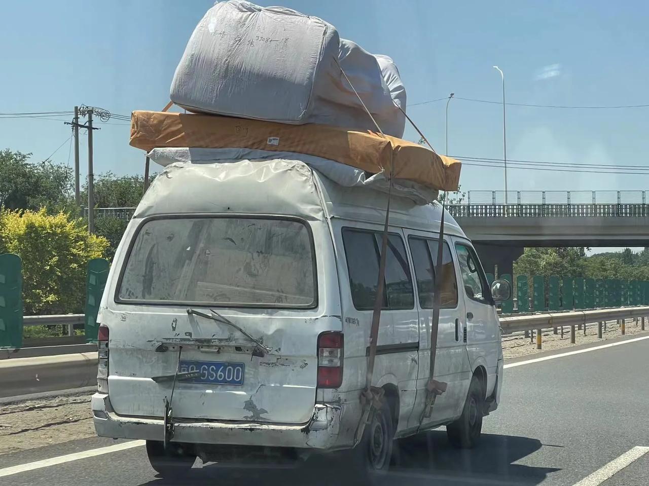 车牌刻意遮挡，超慢速行驶于高速公路内侧，车顶顶两张床跟一张大沙发，这交警抓到得扣