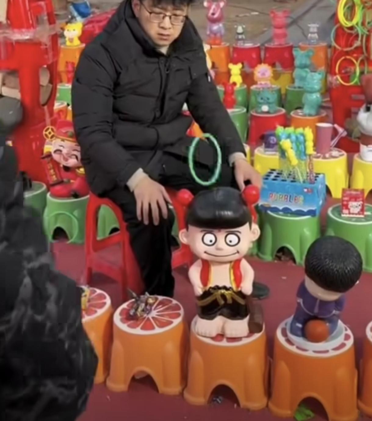 顾客想套“哪吒”
套了一天也套不住
老板见他很执着，于是出手相助，顾客一直套，老