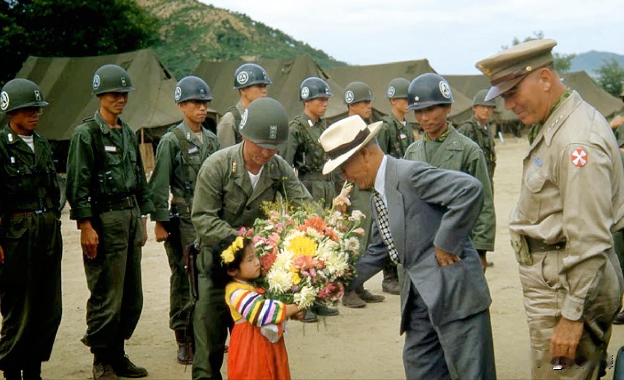 这是抗美援朝期间的一张照片。
照片中的小女孩穿着韩国传统服装，正在给照片中唯一没