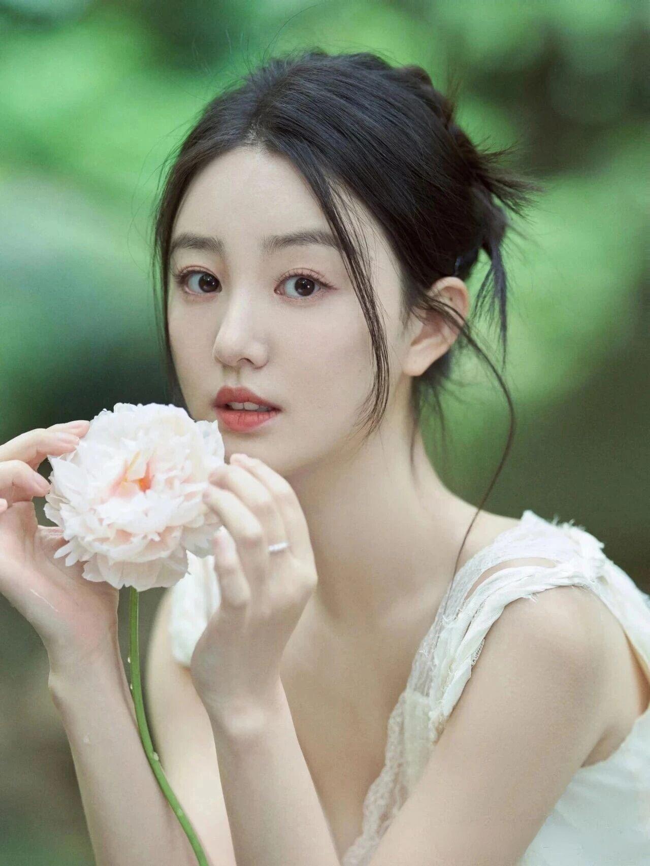 这位女子的美，是自然与温柔的完美交融，在绿意盎然的林间溪边，像从画中走出来的精灵