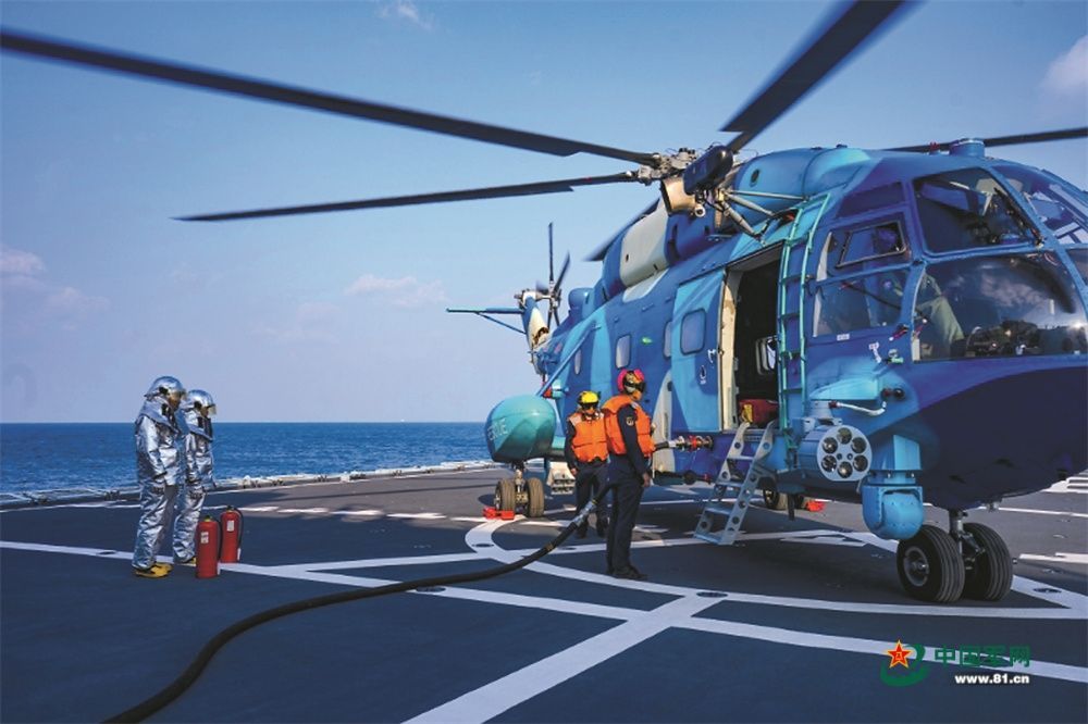 前不久，中部战区空军某部与海军某部开展海上联合搜救训练。图为机械员进行舰载平台“