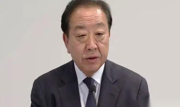 日本前首相野田佳彦，站在了一排水泄不通的镜头前。
他身后，是刚刚出炉的、惨烈到堪