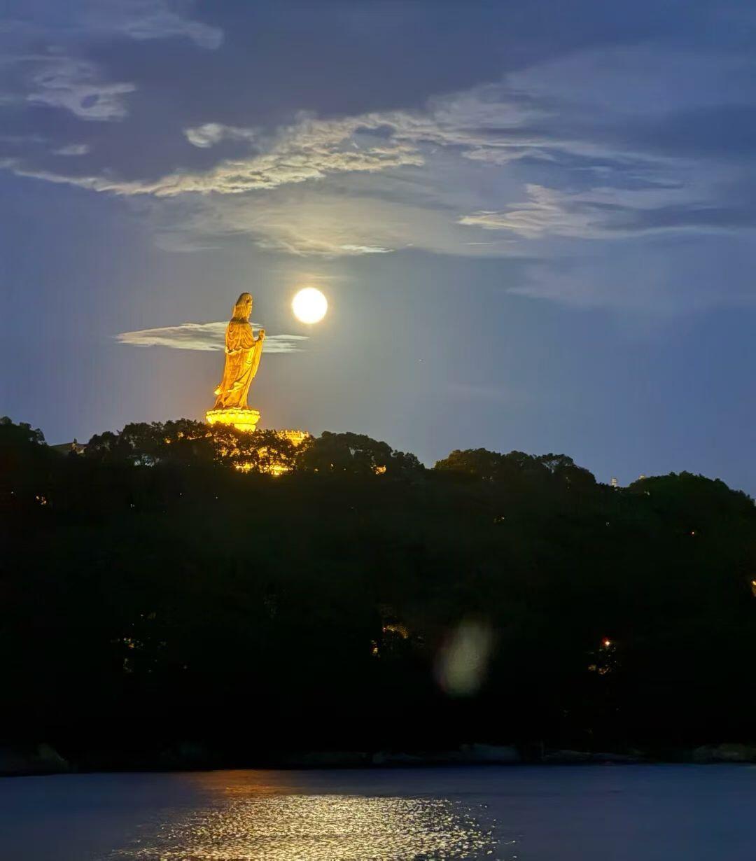 月夜观音：山海间的信仰与清辉月夜下，普陀山观音像静静伫立。明月高悬，清辉洒落，与