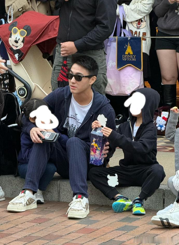 何猷君带孩子们游玩迪士尼 何猷君带儿女游玩迪士尼，还和孩子一起坐在地上看花车表演