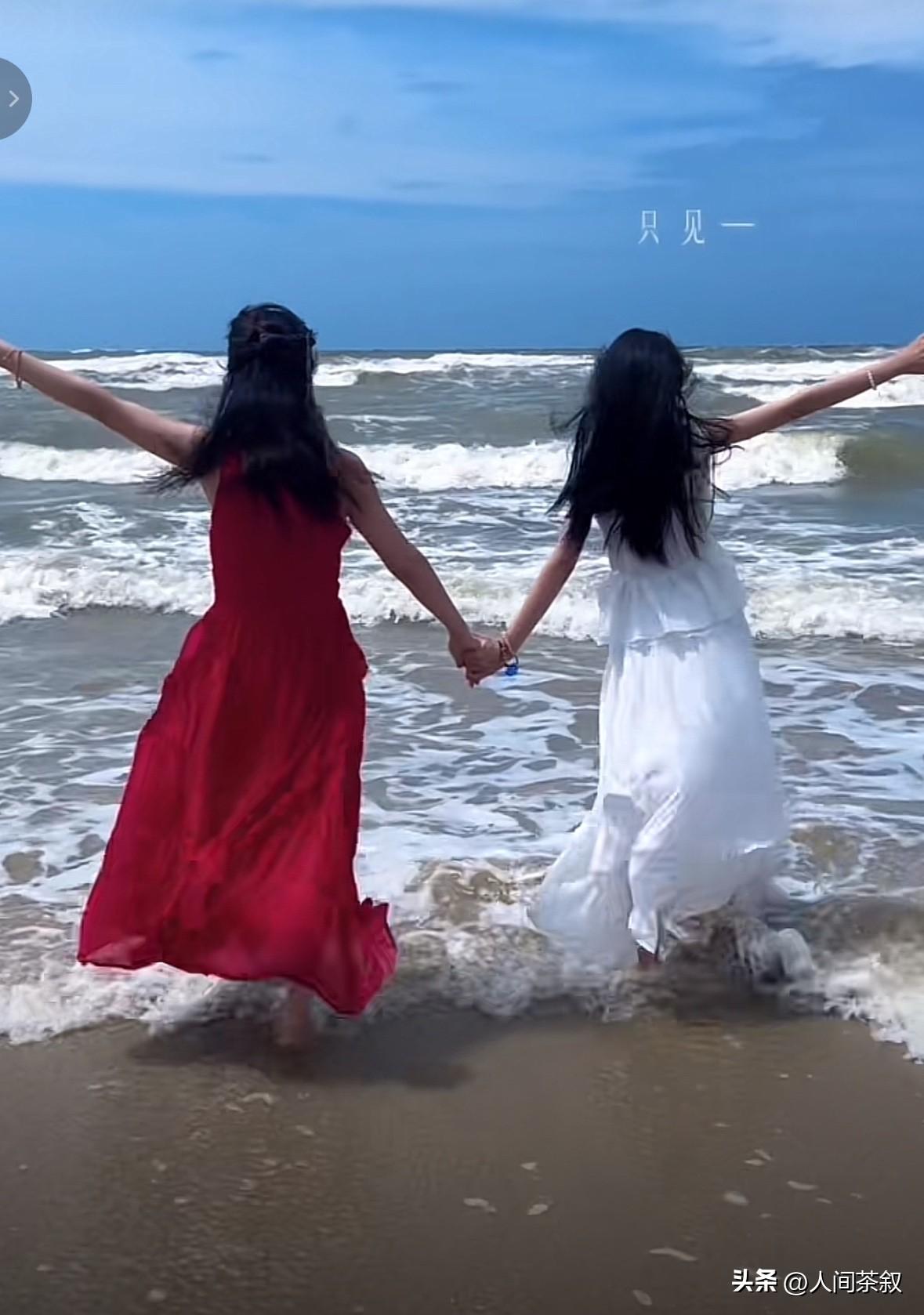 太美了！田静晒了和悦悦一起在广西海边的美美视频，画面中，田静一袭长款红裙，悦悦一