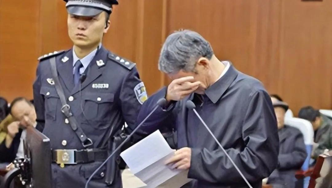 【扯下那件行政夹克：贪官受审，必须统一着囚服！】电视画面一亮，被告席上那人坐得四