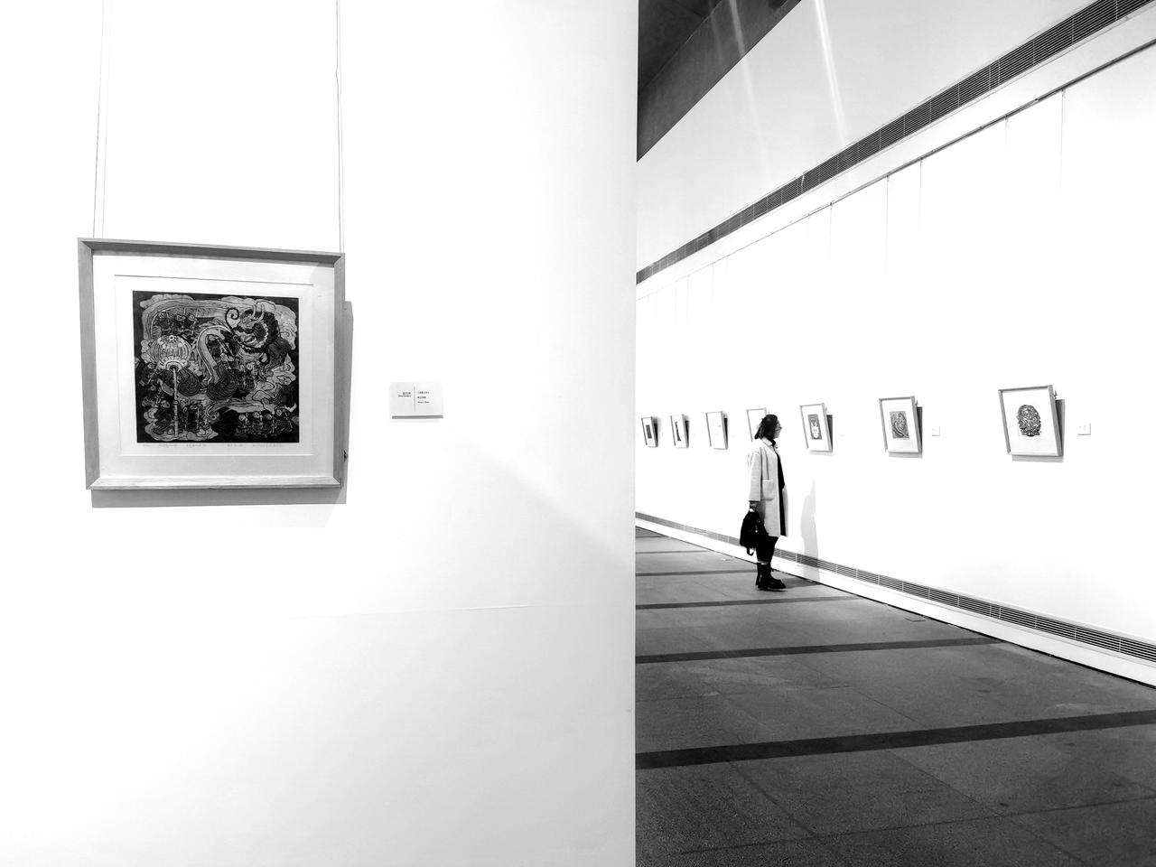 白墙拉长了展厅的寂静，游人放慢脚步，独自站在画作前。喧嚣被隔在展馆之外，此刻世界